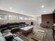 Spacious finished basement featuring a cozy living area with large leather sectional and brick fireplace at 8233 W 62Nd Pl, Arvada, CO 80004