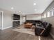 Finished basement featuring a large brown leather sectional, fireplace, and a wall-mounted television at 8233 W 62Nd Pl, Arvada, CO 80004