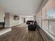 Bright living room with a leather sectional sofa, a fireplace, and large windows that let in natural light at 8233 W 62Nd Pl, Arvada, CO 80004