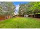 Large grassy backyard with mature trees, hammock, and full fencing for privacy at 2905 S Deframe Way, Lakewood, CO 80228