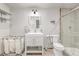 Modern bathroom with decorative mirror, vanity with drawers, open shelving, and glass enclosed shower at 2905 S Deframe Way, Lakewood, CO 80228