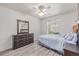 Bedroom with wood-look floors features a bed with blue comforter, ceiling fan and a dark wood dresser at 2905 S Deframe Way, Lakewood, CO 80228