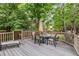 Spacious outdoor deck with outdoor dining set, lounge chairs, a grill, and surrounded by mature trees at 2905 S Deframe Way, Lakewood, CO 80228