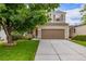 Charming two-story home with a well-maintained lawn, landscaping, and attached two-car garage at 2905 S Deframe Way, Lakewood, CO 80228