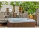 Inviting backyard hot tub adjacent to outdoor dining area with deck and partial fence at 2905 S Deframe Way, Lakewood, CO 80228