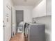 Laundry room with tile flooring features a modern washer and dryer and white storage cabinets at 2905 S Deframe Way, Lakewood, CO 80228