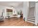 Open-concept living room with hardwood floors, a ceiling fan, and staircase at 2905 S Deframe Way, Lakewood, CO 80228