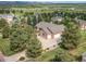 Aerial view of the property showcasing a spacious lot, mature trees, and a three-car garage at 1660 Old Antlers Way, Monument, CO 80132