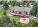 Aerial view showcasing a deck, backyard patio with a firepit, and lush greenery at 1660 Old Antlers Way, Monument, CO 80132