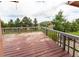Wooden deck offers scenic views of mature trees, nearby homes, and the stunning mountain landscape in the distance at 1660 Old Antlers Way, Monument, CO 80132