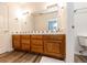 Bathroom with wood cabinets, a large mirror and tile accents at 1660 Old Antlers Way, Monument, CO 80132