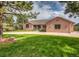 Brick home exterior with a large front yard, mature trees, and a circular driveway at 1660 Old Antlers Way, Monument, CO 80132