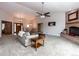 Spacious living room with a brick fireplace, large windows, and open access to other rooms at 1660 Old Antlers Way, Monument, CO 80132