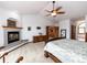 Spacious bedroom suite features a fireplace, dresser, ceiling fan, and a walk-out deck at 1660 Old Antlers Way, Monument, CO 80132