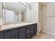 Bathroom featuring double sinks, vanity, large mirror, and tiled floor at 7440 S Blackhawk St # 7-303, Englewood, CO 80112