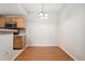 Bright dining room with hardwood floors and a modern chandelier adjacent to the kitchen area at 7440 S Blackhawk St # 7-303, Englewood, CO 80112