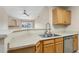 Kitchen bar overlooking living space, featuring double sink and stainless steel dishwasher at 7440 S Blackhawk St # 7-303, Englewood, CO 80112