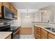 An open kitchen with stainless appliances leading to a dining area with chandelier at 7440 S Blackhawk St # 7-303, Englewood, CO 80112