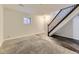 Basement area featuring vinyl flooring, carpet, stairs, and a small window for natural light at 14006 E Utah Cir, Aurora, CO 80012