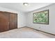 Bright bedroom with carpet floors, closet, and scenic view of nature through the window at 1037 Wagonwheel Gap Rd, Boulder, CO 80302