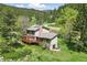 Stunning home exterior with a large deck surrounded by lush greenery and a serene mountain backdrop at 1037 Wagonwheel Gap Rd, Boulder, CO 80302