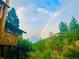 Exterior view of property with a rainbow arching over the trees in the background at 1037 Wagonwheel Gap Rd, Boulder, CO 80302