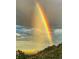 Scenic view of a vibrant rainbow stretching across the sky with trees in the foreground at 1037 Wagonwheel Gap Rd, Boulder, CO 80302