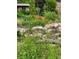 Rock features are surrounded by wildflowers and lush greenery throughout the yard at 1037 Wagonwheel Gap Rd, Boulder, CO 80302