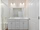 Bright bathroom featuring a double vanity with white cabinetry and a large mirror, complemented by a glass-enclosed shower at 27639 E 7Th Ln, Aurora, CO 80018