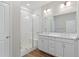 Modern bathroom features a glass enclosed shower and a double sink vanity with quartz countertop and white cabinets at 27639 E 7Th Ln, Aurora, CO 80018