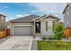 Charming home features a gray exterior, well-maintained lawn, and a two-car garage at 27639 E 7Th Ln, Aurora, CO 80018