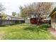 Spacious backyard features a lush lawn, mature tree, wooden fence, and a storage shed at 1275 Niagara St, Denver, CO 80220