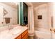 Bathroom with marble tile, wood vanity, and built-in storage at 1275 Niagara St, Denver, CO 80220