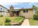 Inviting home with a stone chimney, green awning, and landscaped walkway at 1275 Niagara St, Denver, CO 80220