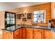 Charming kitchen features wood walls, cabinets, and shelves, with a black door and a window for natural light at 1275 Niagara St, Denver, CO 80220