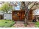 A log cabin style outbuilding with a log door, small windows, and pea gravel surrounding the base at 1275 Niagara St, Denver, CO 80220