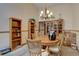 Classic dining room with an oval wooden table, upholstered chairs, and glass-fronted cabinets at 4231 S Fairplay Cir # A, Aurora, CO 80014