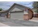 Attached two-car garage exterior featuring brick and neutral siding under a blue sky at 4231 S Fairplay Cir # A, Aurora, CO 80014