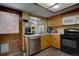 Efficient kitchen with oak cabinets, a stainless steel dishwasher, and access to the outside at 4231 S Fairplay Cir # A, Aurora, CO 80014