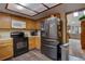 Kitchen features a microwave, black oven, wood cabinets, and stainless steel refrigerator at 4231 S Fairplay Cir # A, Aurora, CO 80014