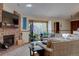 Comfortable living area featuring a brick fireplace, large window with plants, and a cozy couch at 4231 S Fairplay Cir # A, Aurora, CO 80014