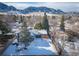 Aerial view of a two-story home with a wooden pergola and snow-covered landscaping at 1120 Hartford Dr, Boulder, CO 80305