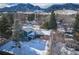 Aerial view of a two-story home with pergola, snow-covered yard and mountain views at 1120 Hartford Dr, Boulder, CO 80305