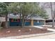 Exterior of a home featuring a blue brick facade, orange shutters, and mature trees in a landscaped front yard at 1120 Hartford Dr, Boulder, CO 80305