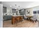Beautiful kitchen boasts modern gray cabinets, stainless appliances, large island, and adjacent dining area at 1120 Hartford Dr, Boulder, CO 80305