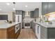 Bright and modern kitchen features stainless steel appliances, custom cabinets, white countertops, and a center island at 1120 Hartford Dr, Boulder, CO 80305