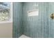 Shower featuring blue subway tile walls, a niche, and stone pebble flooring at 1120 Hartford Dr, Boulder, CO 80305