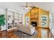 Cozy living room featuring a stone fireplace, built-in shelving, and hardwood floors at 8962 Sunset Ridge Ct, Highlands Ranch, CO 80126