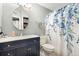 Bright bathroom with a navy vanity, modern lighting, and a stylish blue floral shower curtain at 3663 S Sheridan Blvd # O15, Denver, CO 80235