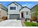 Charming two-story home featuring a modern farmhouse design, gray garage door and a bright red front door at 9286 Telluride Ct, Commerce City, CO 80022